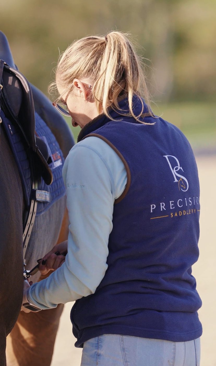 Rhi adjusting the girth during a saddle fitting
